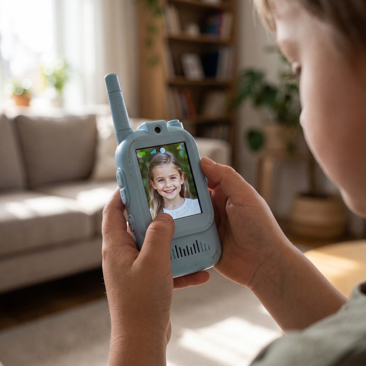 Child's hands holding the video walkie talkie with a sibling on the screen