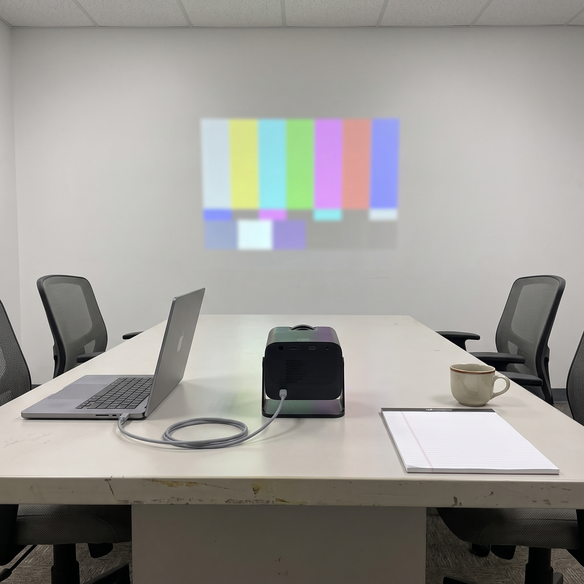 Mini projector connected to a laptop projecting a slide in a meeting room