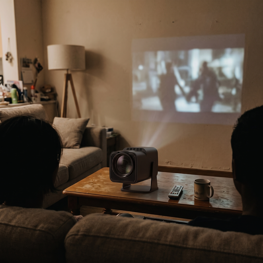 360 rotatable mini projector on a coffee table projecting a movie onto a living room wall