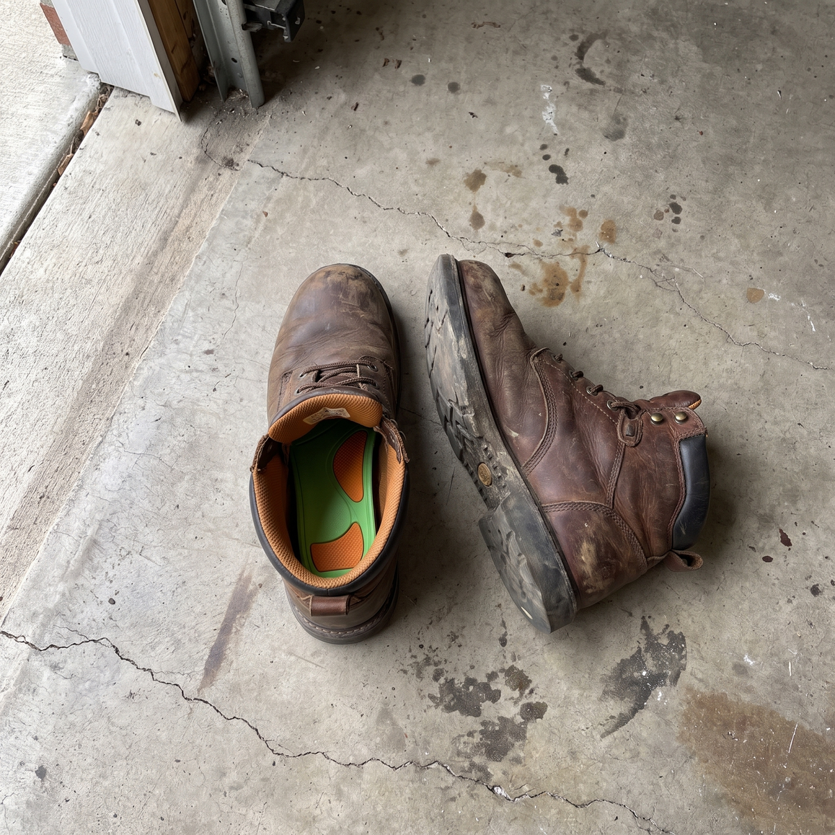 Leather work boot on a garage floor with the arch support insole inside
