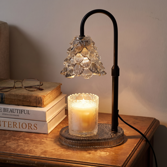Candle warmer lamp lit over a jar candle on a living room side table